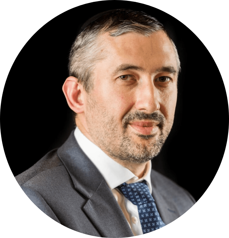 Man in suit with a beard, smiling — COO